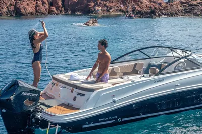 Recreatieboot met twee personen bij rotsen