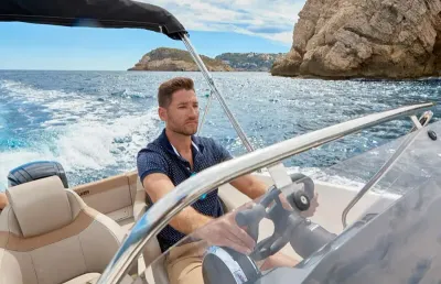 man stuurt motorboot op open zee