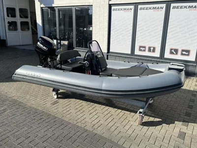 grijze rubberboot met console en buitenboordmotor