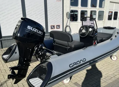 Opblaasbare boot met buitenboordmotor bij gebouw