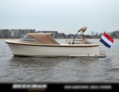 sloep op water met Nederlandse vlag