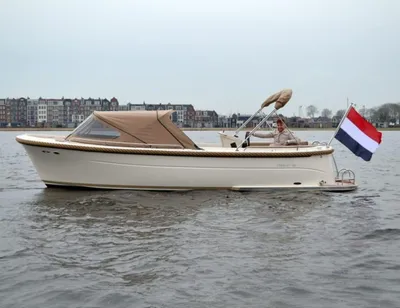 sloep op water met kap en Nederlandse vlag