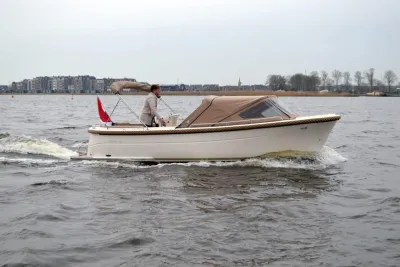 witte sloep vaart op het water met stuurman