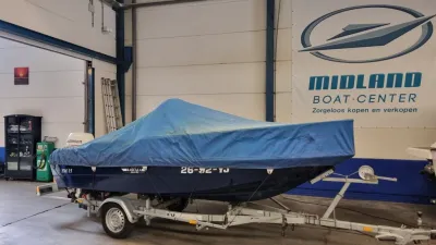 boot met dekzeil op trailer in loods