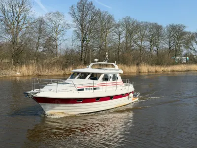 motorjacht op rivier met bomen langs oever