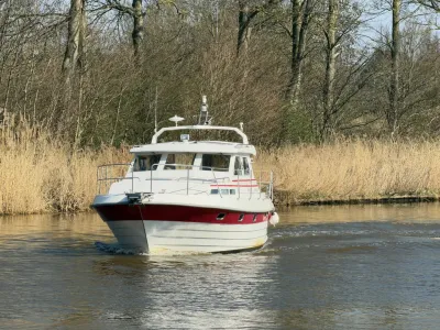 motorjacht op rivier met riet en bomen