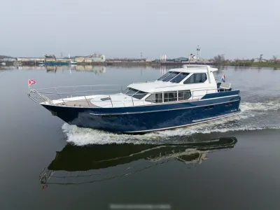 wit-blauw motorjacht op kalm water