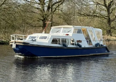 motorjacht op rivier met bomen op achtergrond