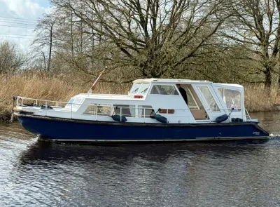 zijaanzicht van motorjacht op water bij riet
