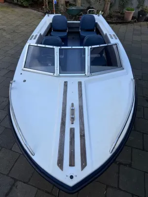 witte sportboot op oprit met vier stoelen