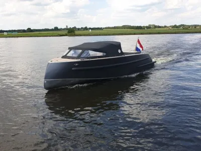 zwarte tender op water met afdekzeil