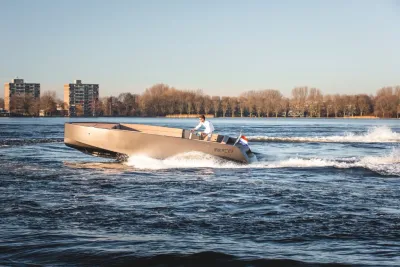 tender vaart op rivier met bomen en gebouwen