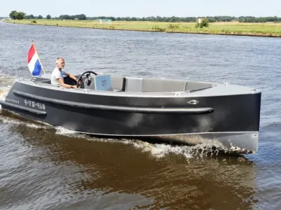 grijze tenderboot met bestuurder op water