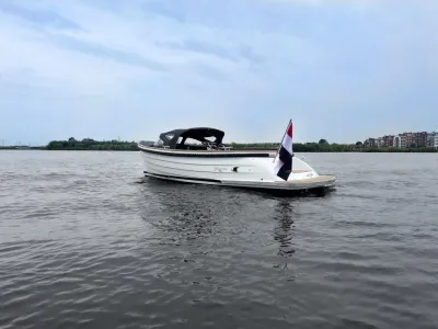 witte sloep op open water met vlag