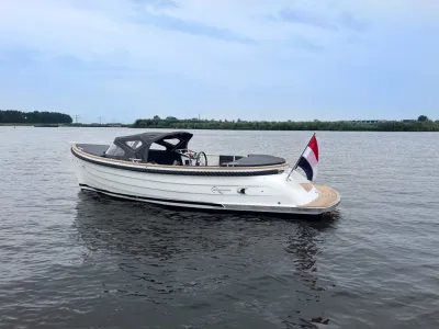 witte sloep op water met Nederlandse vlag