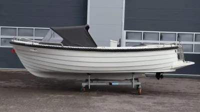 witte sloep op trailer voor bedrijfspand