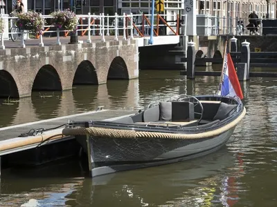 sloep aangemeerd in gracht bij kade