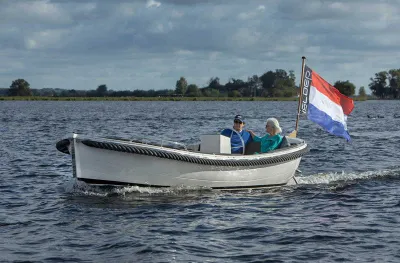 witte sloep met twee personen op het water
