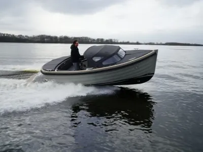 grijze tender op het water met bestuurder