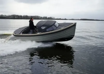 grijze tender op het water met bestuurder