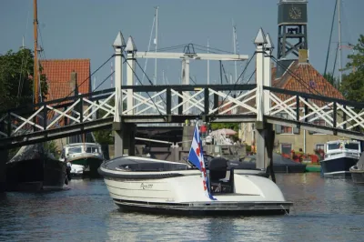 sloep in kanaal voor houten ophaalbrug