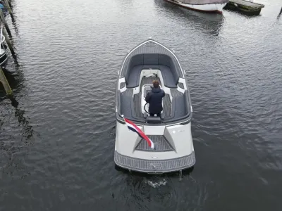 open sloep met bestuurder op stil water