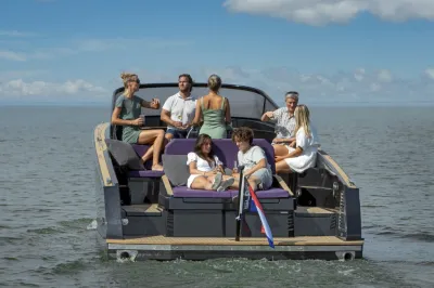 mensen op achterdek van sloep op open water