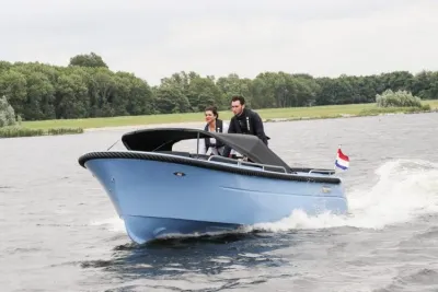 blauwe tender met twee opvarenden op het water