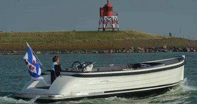 motorboot op rustig water bij vuurtoren