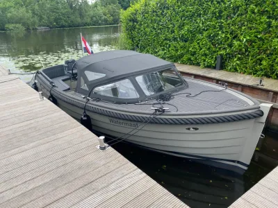 grijze sloep afgemeerd bij steiger