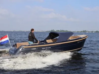 sloep op open water met stuurman