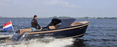 sloep op open water met stuurman