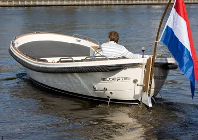 sloep met persoon en Nederlandse vlag