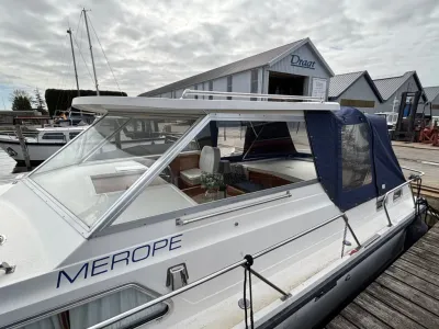 Motorboot afgemeerd bij steiger met kajuit