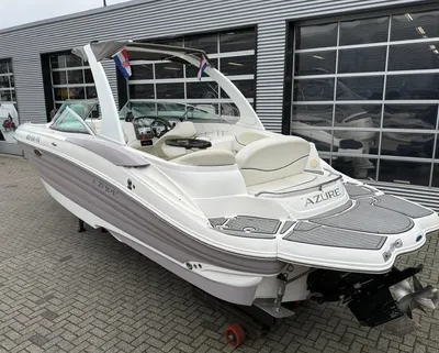 witte bowrider op parkeerplaats bij loods