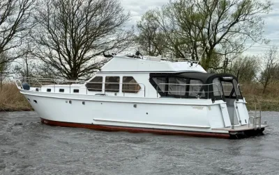 wit motorjacht op rivier met bomen op achtergrond