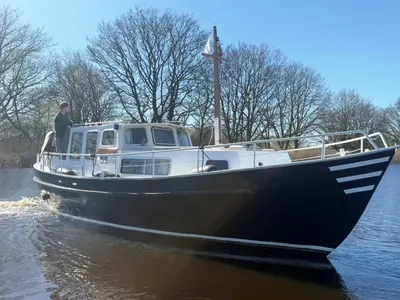 kotter op rustig water met bomen op de achtergrond