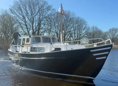 kotter op water met bomen op de oever
