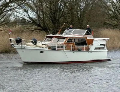 motorkruiser op rustig water bij riet