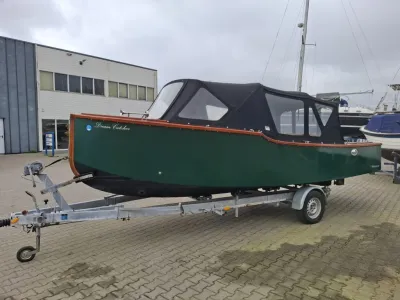 groene boot op trailer bij jachthaven