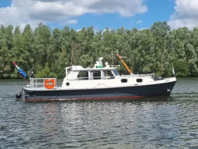 motorjacht op rivier bij beboste oever