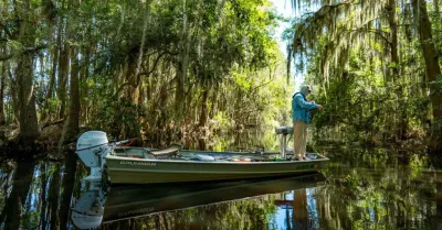 vissende persoon op kleine boot in moerassen