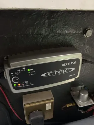 acculader bevestigd aan wand in bootinterieur