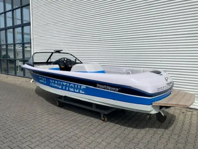 sportboot op kar naast gebouw