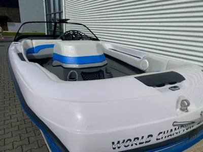 witte speedboot bij metalen gevel