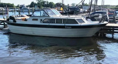 wit motorjacht aangemeerd in jachthaven