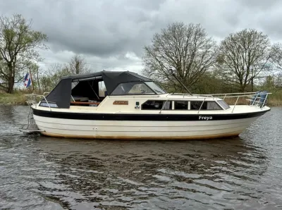 motorjacht in kanaal bij bomen