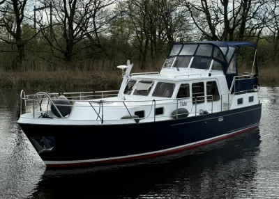 Motorjacht op stil water bij bomen