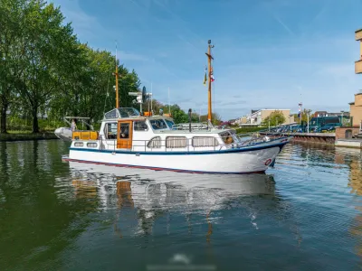 klassiek motorjacht in kanaal