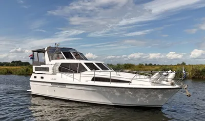 wit motorjacht op rivier bij bewolkte hemel